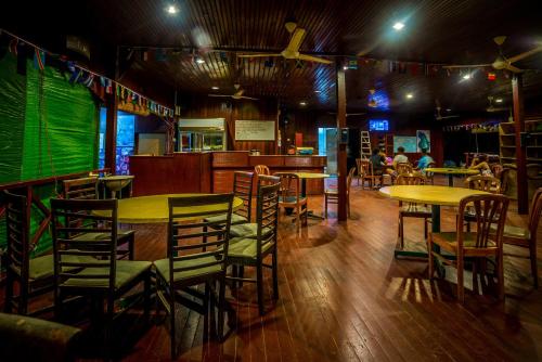 a restaurant with tables and chairs in a room at Juara Beach Resort in Tioman Island