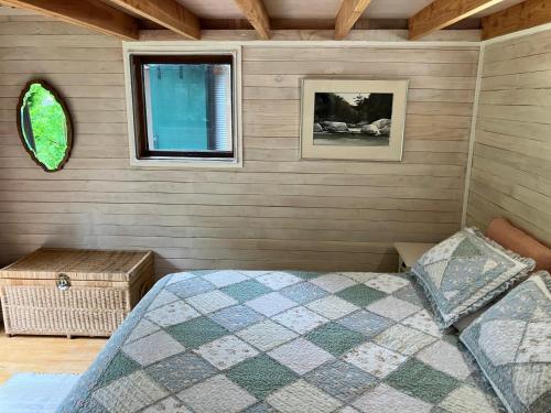 a bedroom with a bed and a window at RIMU CABIN At the Bridge in Motungarara