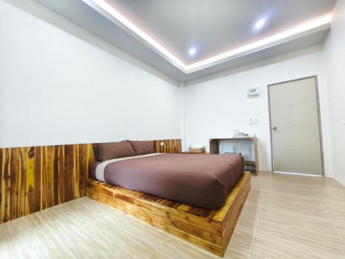 a bedroom with a bed with a wooden bed frame at Nan Minimal ที่พักน่านมินิมอล in Ban Na Tho
