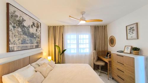 ein Schlafzimmer mit Bett, Schreibtisch und Fenster in der Unterkunft CASA BLANCA Port Royale - heated pool, ocean view, fibre net in Los Cristianos