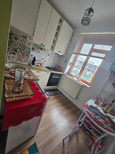 a kitchen with white cabinets and a red counter top at Mery in Craiova