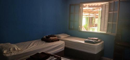 two beds in a blue room with a window at Camping-Casa Saco do Ceu in Saco do Ceu