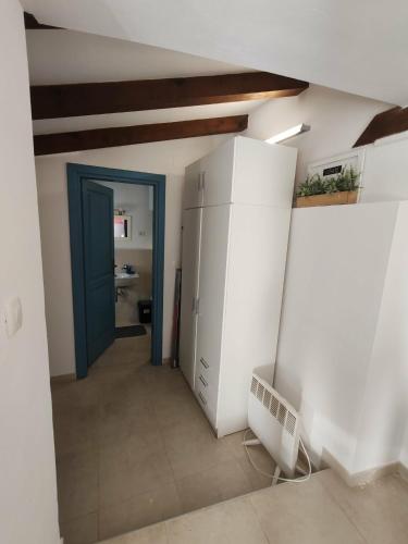 ein Flur mit einer blauen Tür und einem Badezimmer in der Unterkunft ManuIris in Butkovići