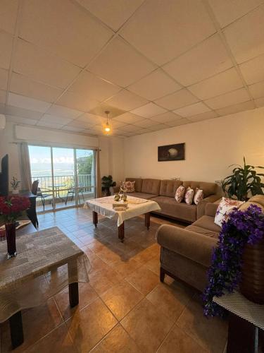 una sala de estar con un sofá y una mesa en Large Vacation Apartment With A Stunning View In Isfiya, Mount Carmel - דירת נופש עם נוף מדהים בעספיא, en ‘Isfiyā