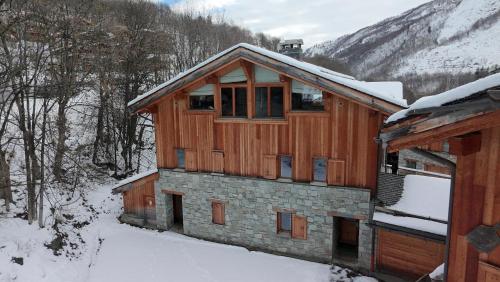 a wooden house with snow on the roof at Le Cochet by Lodji in Saint-Martin-de-Belleville