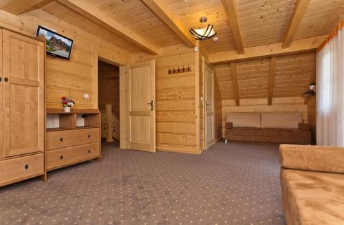 een grote woonkamer met houten wanden en een plafond bij Gorczański Domek - Koninki in Poręba Wielka