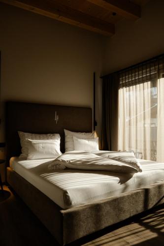 a large bed in a bedroom with a window at LH Linzerhaus Suites Saalbach - inklusive Jokercard in Saalbach-Hinterglemm