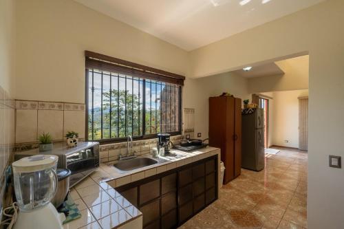 eine große Küche mit einem Waschbecken und einem Fenster in der Unterkunft Villa Familiar 3BR Vistas al Valle & Naturaleza in Turrialba