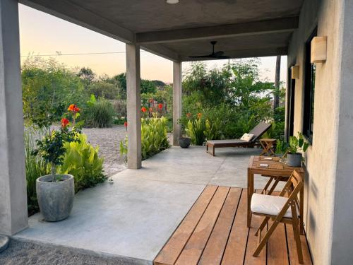 a patio with a table and chairs and flowers at Entire Casita Ocean Breeze & Forest Calm in Troncones