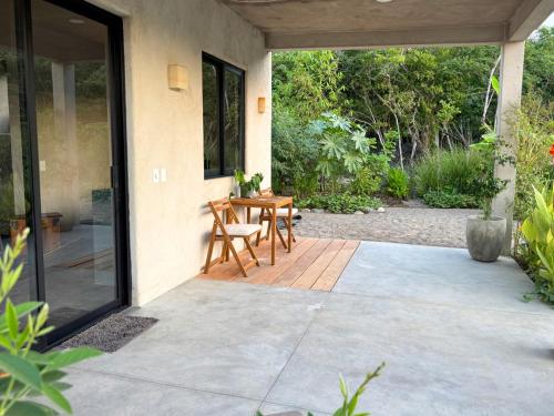 a patio with a table and chairs on it at Entire Casita Ocean Breeze & Forest Calm in Troncones