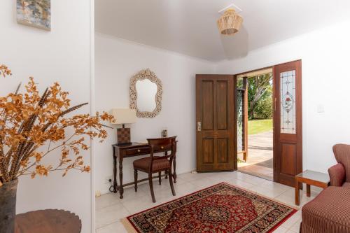 a living room with a door and a table at Selwyn Cottage in Burnt Pine