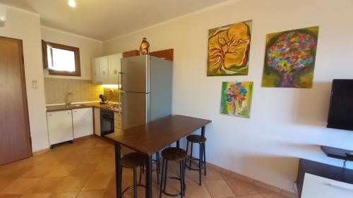 a kitchen with a table and a refrigerator at La Dimora del Filosofo - Eraclito's Home in Olbia