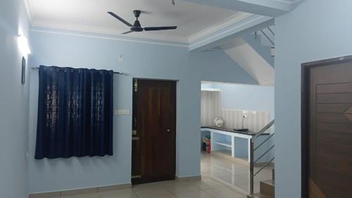 una habitación con un ventilador de techo y una puerta en Urban white villa homestay, en Pondicherry