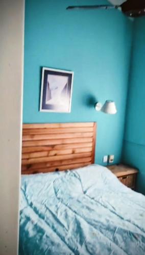 una camera da letto blu con un letto e una parete blu di Duplex Gesell a Villa Gesell