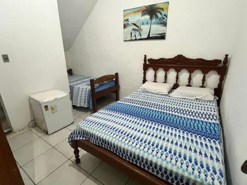 Un dormitorio con una cama con un edredón azul y blanco. en Pousada Jirê, en Itacaré