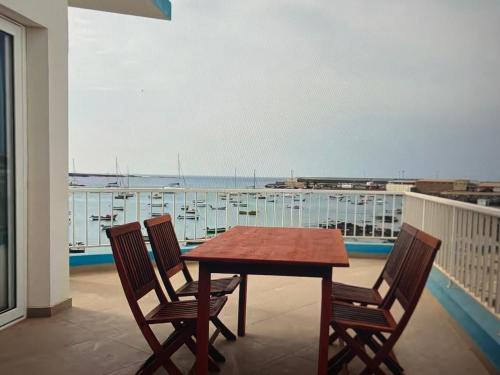 a table and chairs on a balcony with a view of a harbor at The Blue Haven in Sal Rei