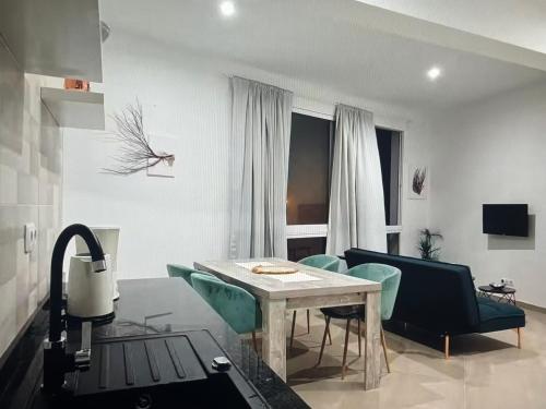 a living room with a table and green chairs at The Blue Haven in Sal Rei