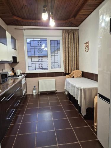 a room with a table in a kitchen with a window at Guest house in Umanʼ