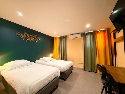 a hotel room with two beds and a desk at Hôtel Beauséjour in Marseille