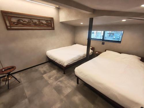 a small room with two beds and a window at Fukuchiya in Fujiyoshida