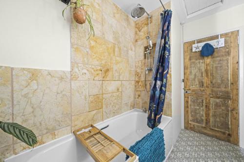 uma casa de banho com uma banheira e uma porta de madeira em Beinn View 3 Bedroom House - Sea View - Ardersier em Ardersier