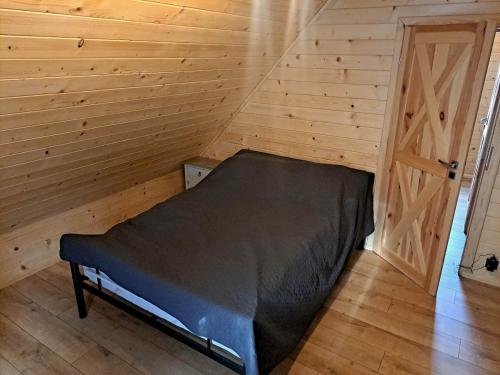 a bedroom with a bed in a wooden room at Juraszówka in Kamesznica