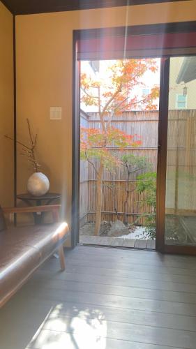 a room with a sliding glass door with a vase at 1-minute walk to Keihan Fushi mi Inari St ation 5-minute walk to Fushi mi Inari T aisha in Kyoto