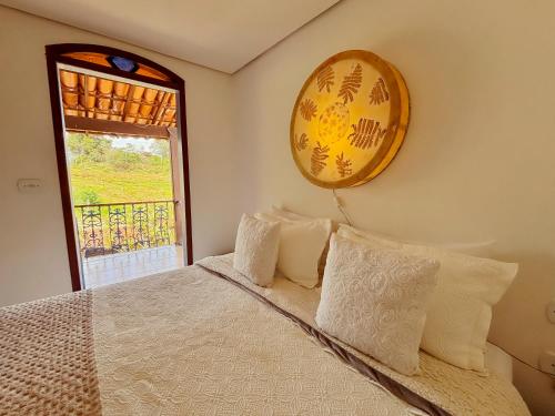a bedroom with a bed and a window at Pousada Travessias in Tiradentes