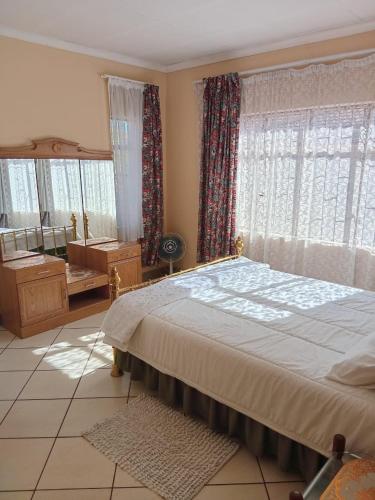a bedroom with a large bed and a large window at VSA SELF CATERING Accommodation Unit 2 entire house ,Sleeps 4-7 in Newcastle