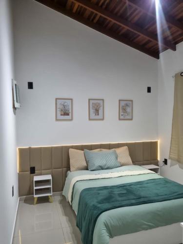 a bedroom with a bed with a green blanket at Chácara Bela Vista in Itajubá