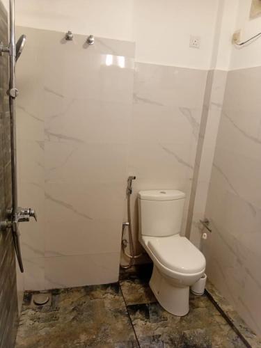 a bathroom with a white toilet in a room at Serenique Greens in Kandy