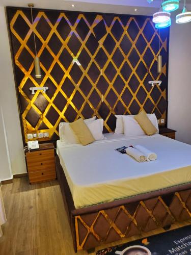 a bedroom with a bed with a wooden headboard at TOUR EIFFEL HoTEL BENIN in Porto-Novo