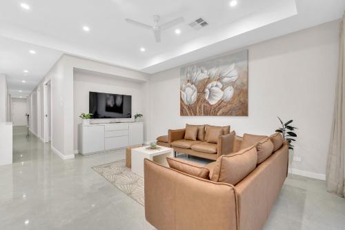 a living room with a couch and a tv at Luxury on Leeds #2 in Northfield