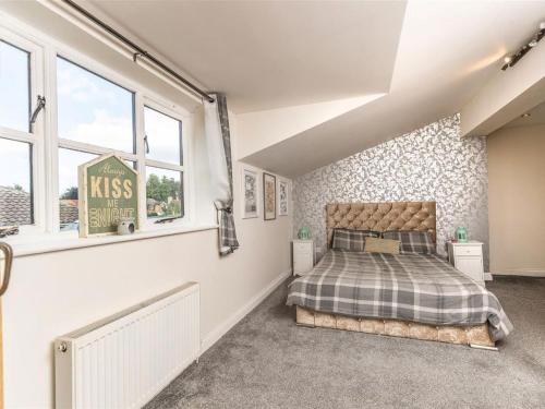 una camera da letto con un letto in una stanza con finestre di Silver Cottage a Scruton