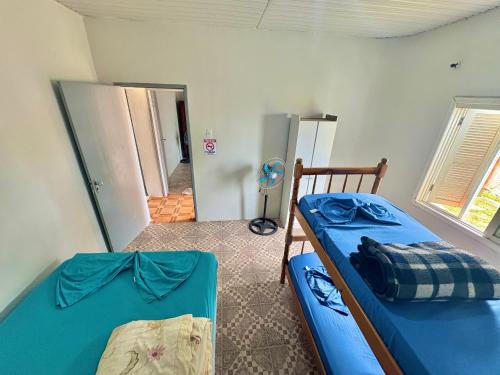 a bedroom with two bunk beds and a hallway at Casa com 2 quartos grandes a 150m da praia in Rio Grande