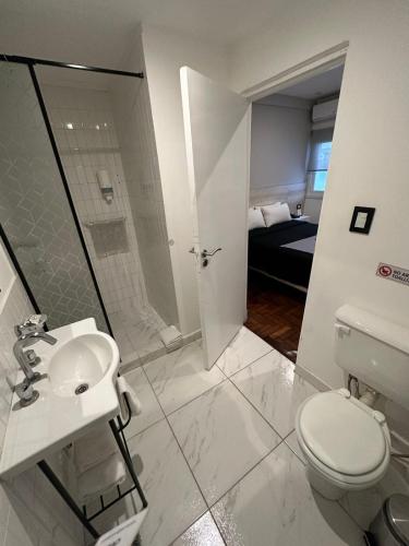 a white bathroom with a toilet and a sink at HotelN26 in Mar del Plata