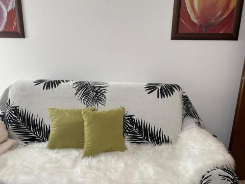 Un sofá blanco y negro con dos almohadas encima. en Casa Silvia, en Chambave