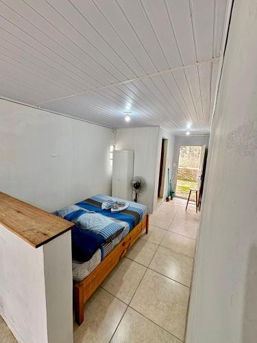 a bedroom with a bed in a white room at Kitnet a 150m da praia com Ar Condicionado in Rio Grande