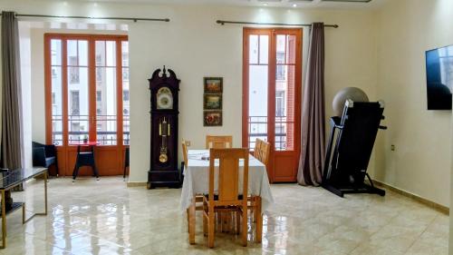 comedor con mesa y reloj de abuelo en Appartement Néoclassique centre -ville, en Casablanca