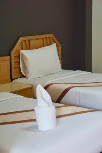 two beds with white towels on top of them at PK Garden Hotel in Ban Chiang Wang