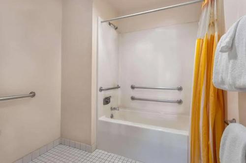 een witte badkamer met een douche en een bad bij Norwood Inn & Suites By BlissPoint in Indianapolis