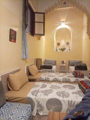 a room with three beds and a couch at Riad Dar Al Manzah in Rabat