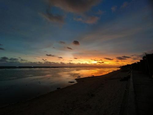 - un coucher de soleil sur une plage donnant sur l'océan dans l'établissement Villa Sahara Hiil, à Cilauteureun