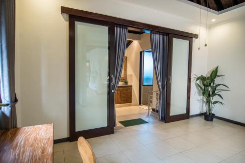 an open hallway with glass doors with a view of the ocean at Wardana Ubud Villa I in Ubud