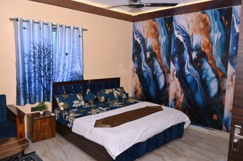 マウント・アブにあるHotel Unique Villaの壁に絵が飾られたベッドのある寝室