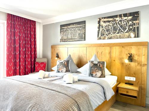 zwei Betten in einem Schlafzimmer mit zwei Hunden drauf in der Unterkunft Bergsonne B15 Montana Haus in Oberstdorf