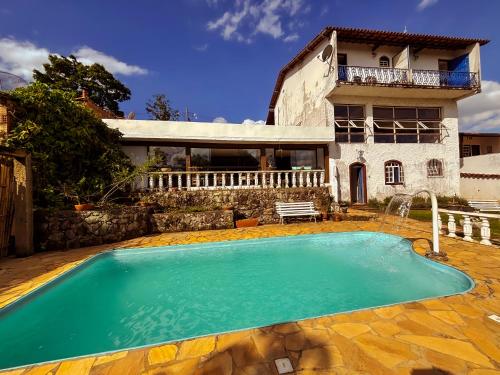 a house with a swimming pool in front of a house at Pousada Travessias in Tiradentes