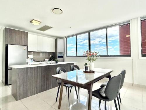 a kitchen with a dining room table and chairs at Modern Penthouse 7-min Walk to Station & Westfield in Sydney