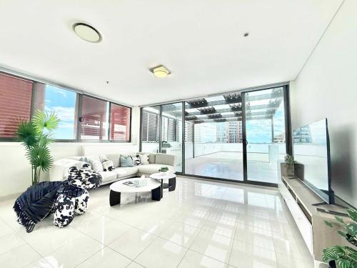 a living room with a couch and a table at Modern Penthouse 7-min Walk to Station & Westfield in Sydney