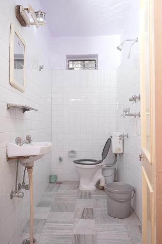 Un baño blanco con inodoro y lavabo. en Hotel Karni Niwas, en Jaipur